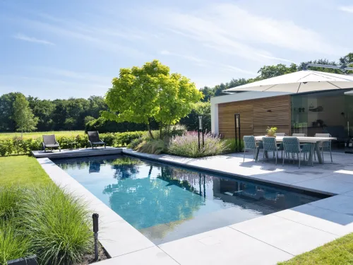 Composiet zwembad XL-Lounger 115, geplaatst in een aangelegde tuin